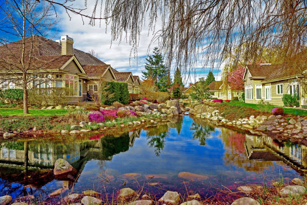 A body of water with houses in the background. Outdoor. Sky. Water. Lake. Boat