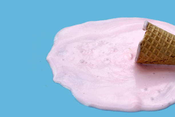 istock Melting ice cream ball with waffle cone on blue background. 2160632881