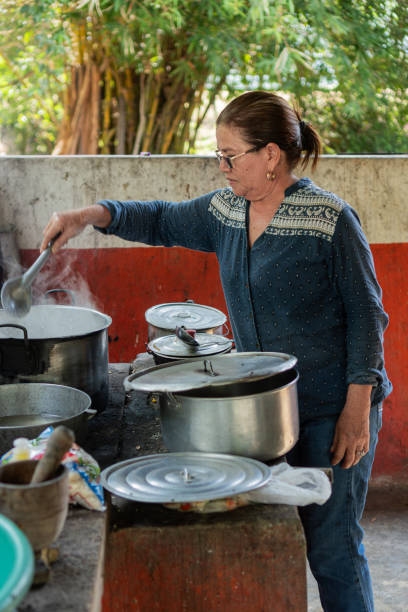 istock Older Woman Cooking in Outdoor Kitchen with Multiple Pot 2160636393