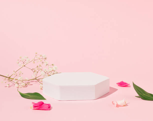 istock Geometric podium platform stand for product presentation and spring flowers on pink background. Mock up scene. Business Concept. Advertisement idea. 2160637775