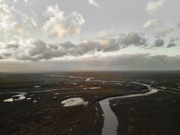 Icelandic volcanic plain with meandering river seen from above with drone