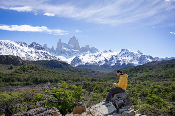 istock man sitting texting from his cell phone in front of the fitz roy 2160642459