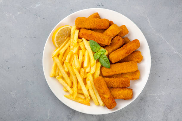 istock Fish and chips .Close up of crispy breaded deep fried fish fingers with breadcrumbs served with remoulade sauce and lemon 2160642878