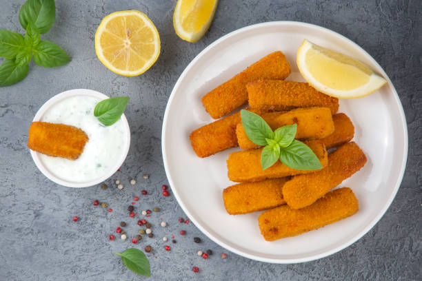 istock Fish and chips .Close up of crispy breaded deep fried fish fingers with breadcrumbs served with remoulade sauce and lemon 2160645030