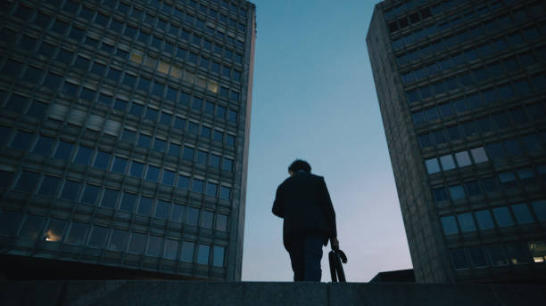 istock Senior Professional Walking by Nighttime Office Towers 2160645798