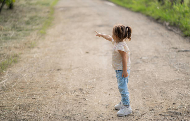 istock little girl outdoors walking and pointing with her hand 2160648340