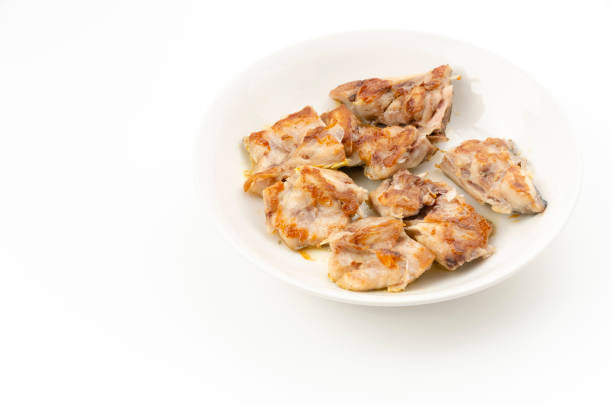 Salted-grilled mahi-mahi scraps on plate on white background