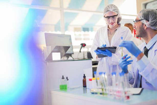 istock scientists perform experiments and record data. people arranges equipment with test tubes and chemicals for producing medicine and biochemistry. man hold tubes of chemical liquids and plant samples. 2160655538