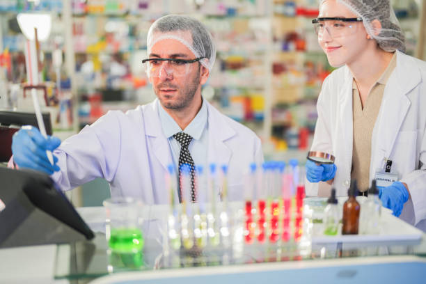 istock scientists perform experiments and record data. people arranges equipment with test tubes and chemicals for producing medicine and biochemistry. man hold tubes of chemical liquids and plant samples. 2160655707