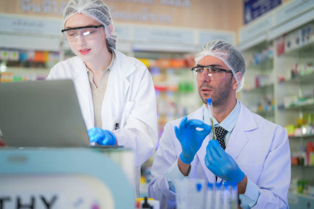 istock scientists perform experiments and record data. people arranges equipment with test tubes and chemicals for producing medicine and biochemistry. man hold tubes of chemical liquids and plant samples. 2160656401