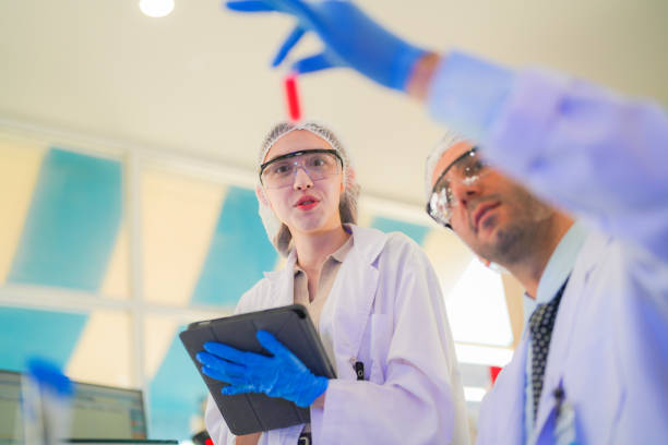 istock scientists perform experiments and record data. people arranges equipment with test tubes and chemicals for producing medicine and biochemistry. man hold tubes of chemical liquids and plant samples. 2160656428