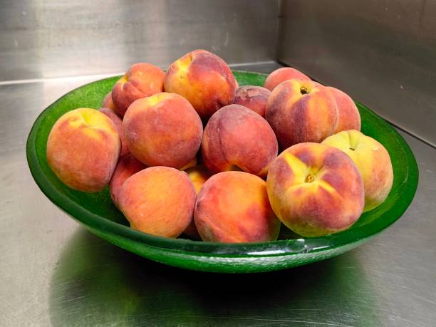 A bowl of juicy and ripe fresh peach fruit.