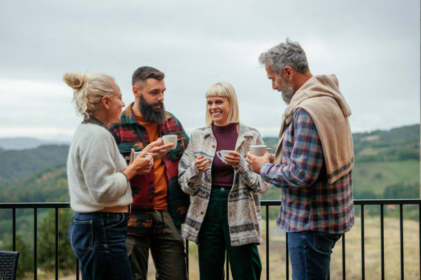 istock Diverse friends having coffee on mountain cabin deck. 2160660987