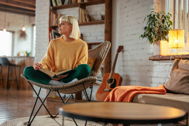 istock Pensive woman reading book at home. 2160661025