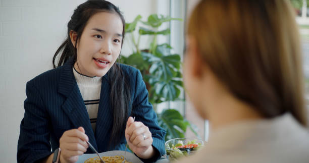 istock Two young business women talk about work during having lunch in the restaurant 2160672882