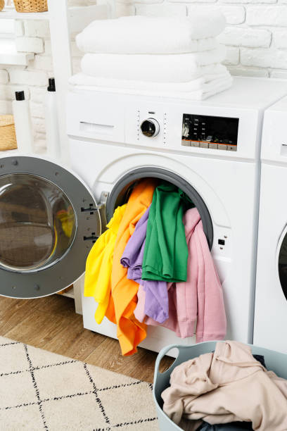 istock Overstuffed Washing Machine Door With Colorful Clothes 2160677997