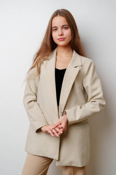 istock Young woman model posing in beige suit against white background 2160678768