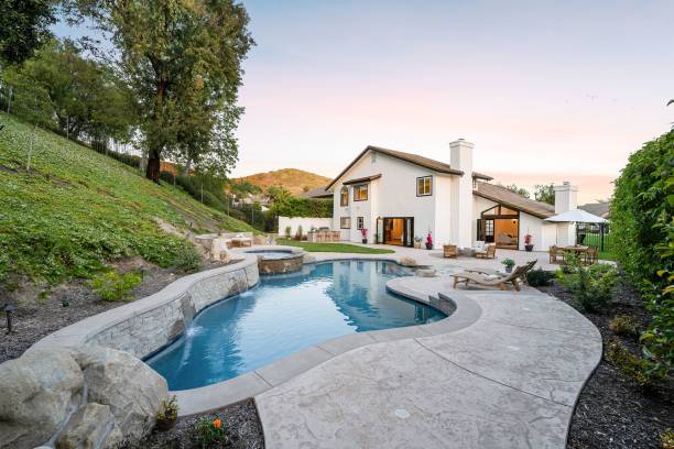istock house with a swimming pool and landscaped backyard at sunset 2160683352
