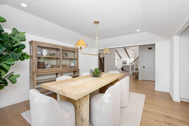 istock dining room with a wooden table, white chairs, and a rustic cabinet in a bright 2160683382