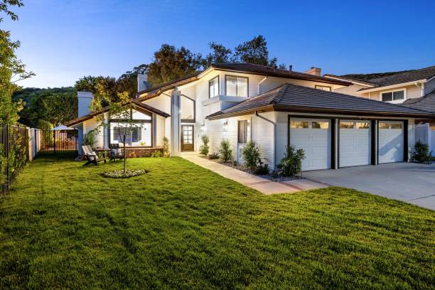 istock suburban house with a manicured lawn and evening lighting 2160683404