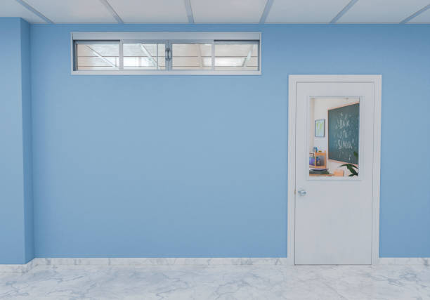 Closed doorway into a classroom with a Back to School message on the chalkboard, seen from a hallway with a blue wall and copy space. Education and learning environment. 3d rendering