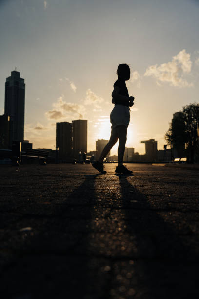 istock The woman is running. Sunset and silhouette. 2160686420