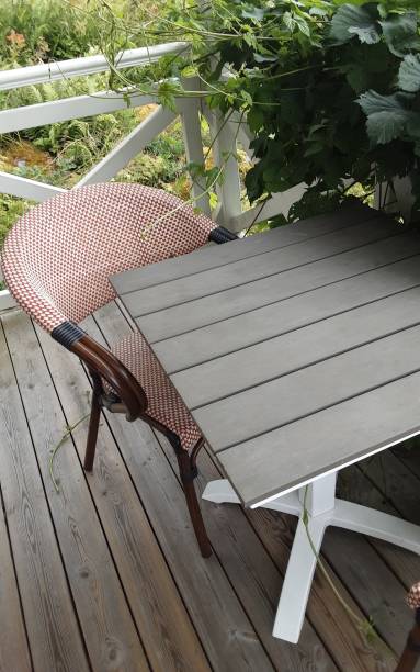 istock Chair and table on an overgrown terrace. 2160686988