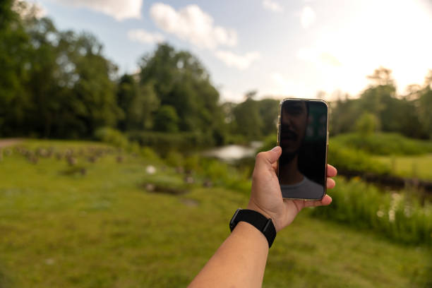istock Young man is taking nature photos with his smartphone. 2160687638
