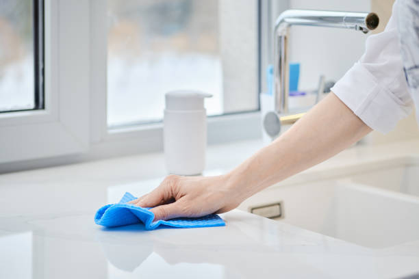 istock Female hand with sponge cleaning stone surface of kitchen tabletop 2160691243
