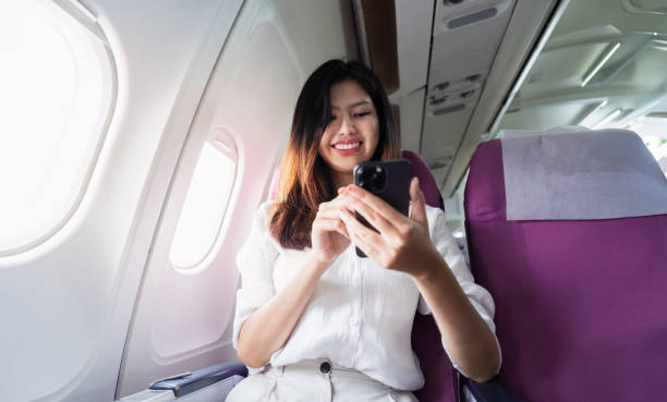 istock Young Woman Using Smartphone on Airplane, Modern Technology and Travel Concept 2160695728