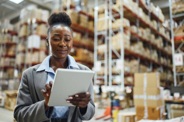 istock Smiling black female inspector working on touchpad in supply chain. 2160696202
