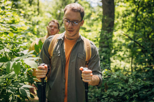 istock Focused man examining the forest flora with poles 2160696486