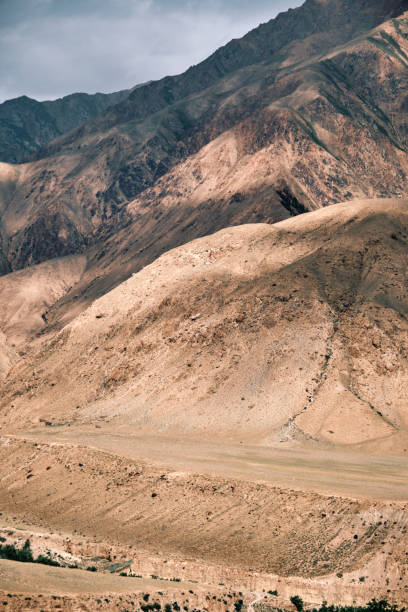 istock Cloudy sky casting shadows on a sandstone canyon amidst towering peaks 2160697257