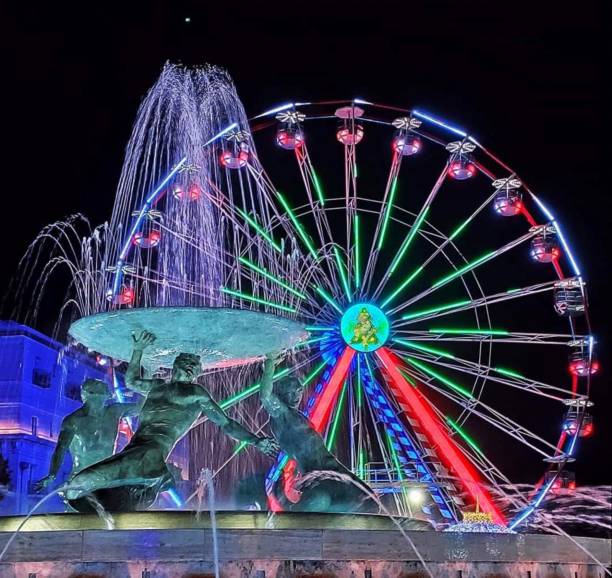 istock Nighttime Spectacle: Illuminated Ferris Wheel and Fountain 2160698027