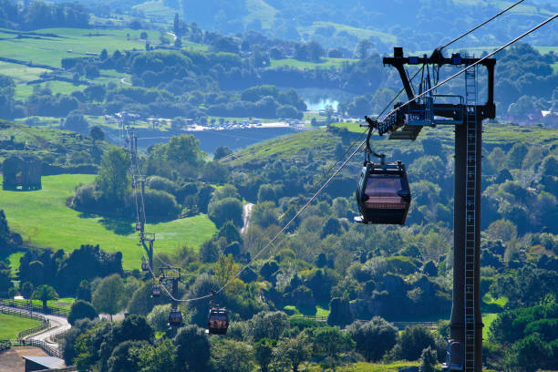 istock A cable car is suspended above a lush green valley. 2160698168