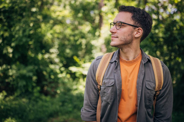 istock Thoughtful man gazing sideways in green forest area. 2160702338