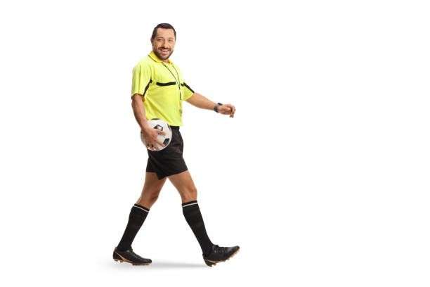 Football referee carrying a ball and walking isolated on white background