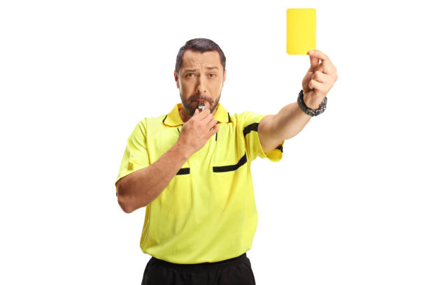 istock Football referee with a yellow card blowing a whistle 2160703094
