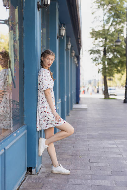 Girl stands leaning against the wall