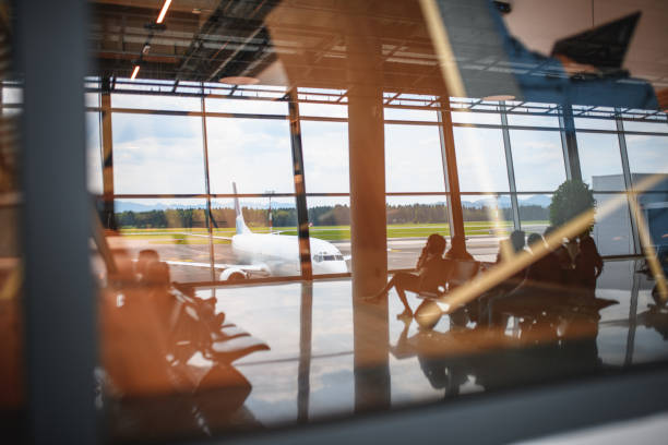 istock Reflection In The Window Of People Waiting For Their Flight 2160708717