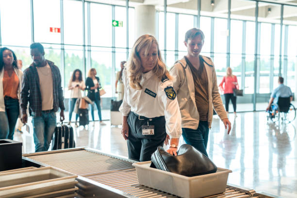 istock Caucasian Male Flyer Proceeding Through Baggage Screening With Help of Security Lady 2160709536