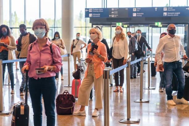 istock Diverse People Checking In At The Airport Wearing Protective Face Masks 2160709687