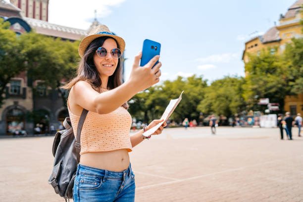 istock Young Female Tourist Taking Selfies While Holding A Map In Subotica 2160710130
