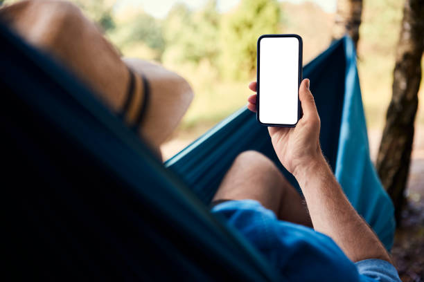 istock Mockup closeup of man using smartphone in hammock 2160714754