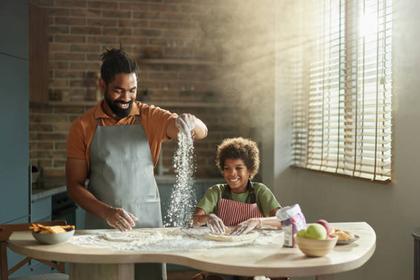istock Happy black father and son making a cake in the kitchen. 2160717428