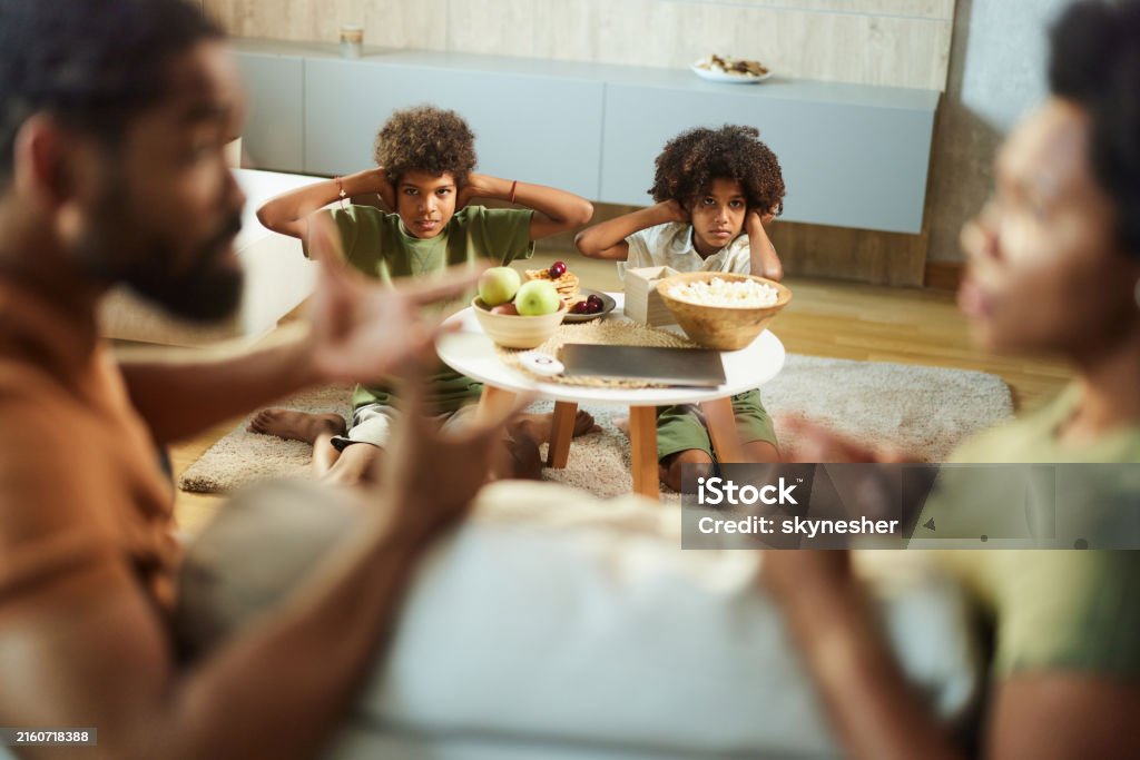 We don't want to listen to them arguing! Displeased black siblings covering their ears while refusing to listen to their parents arguing at home. Child Custody Stock Photo We don't want to listen to them arguing! Displeased black siblings covering their ears while refusing to listen to their parents arguing at home. Child Custody Stock Photo