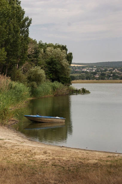 istock Boat on a Calm Lake Shore 2160720036