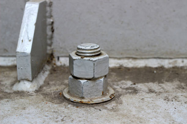 A large, old, rusted nut attached to the steel base structure.