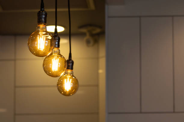 istock Three light bulbs hanging from the ceiling, one of which is lit 2160722457