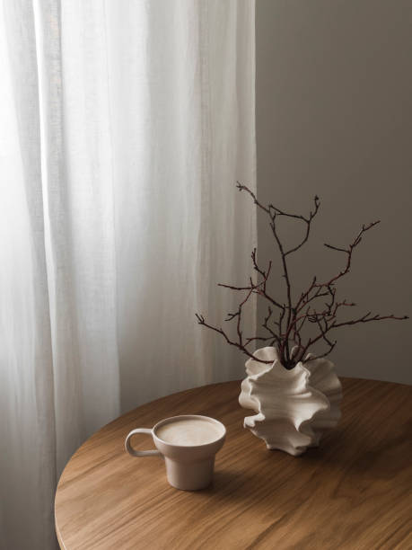 istock Cappuccino cup, creative ceramic vase with dry branches on a round wooden table 2160734038
